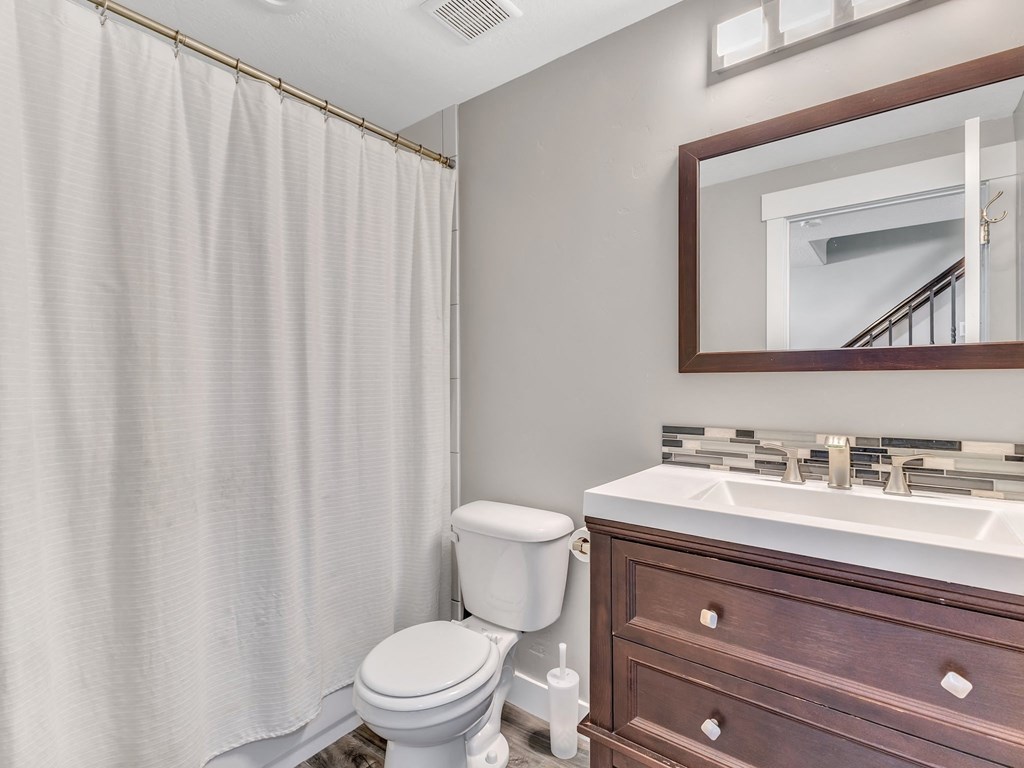 a bathroom with a shower and a sink and a toilet