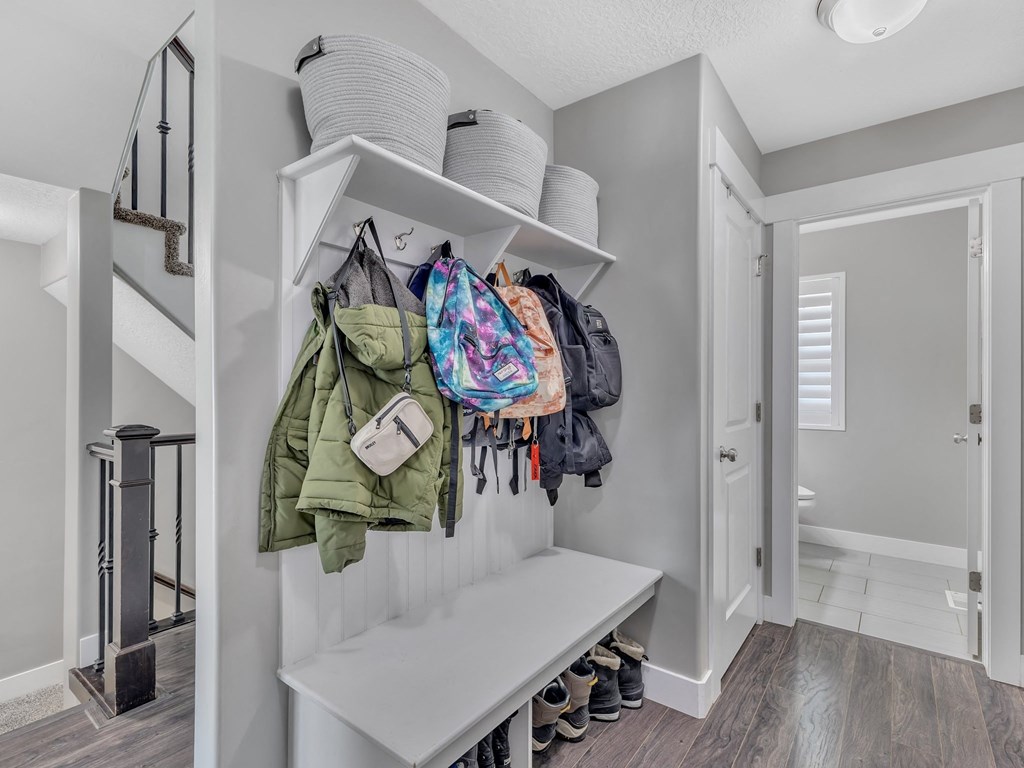 a laundry room with shelves and bags hanging on the wall