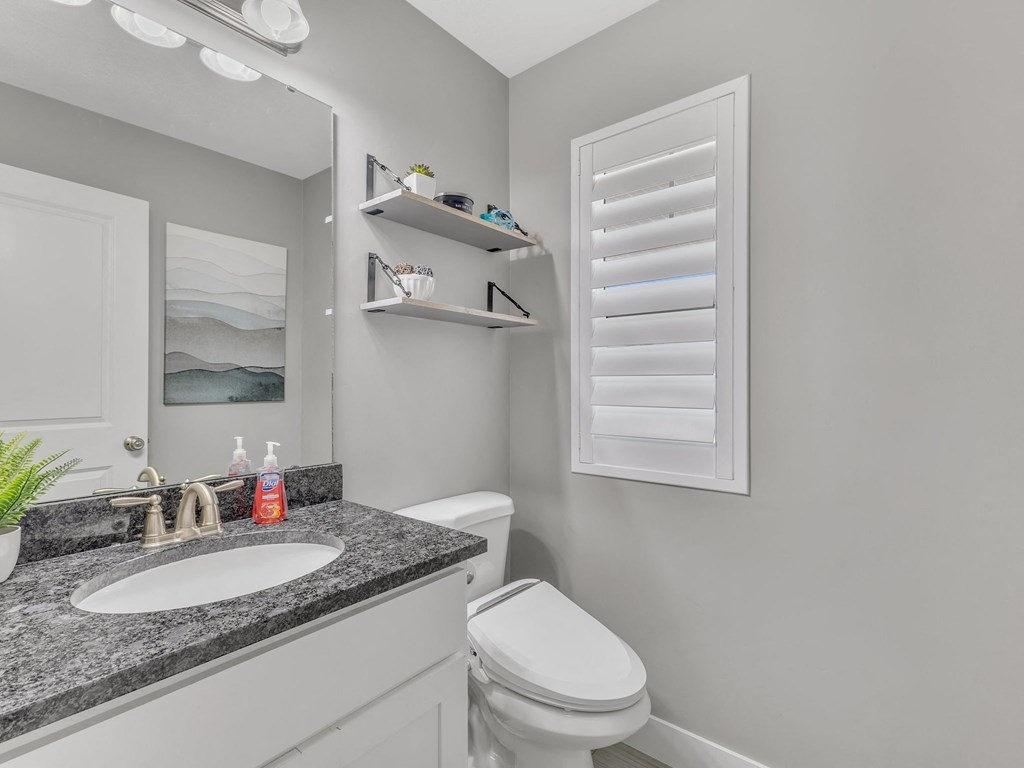a bathroom with a sink toilet and a mirror