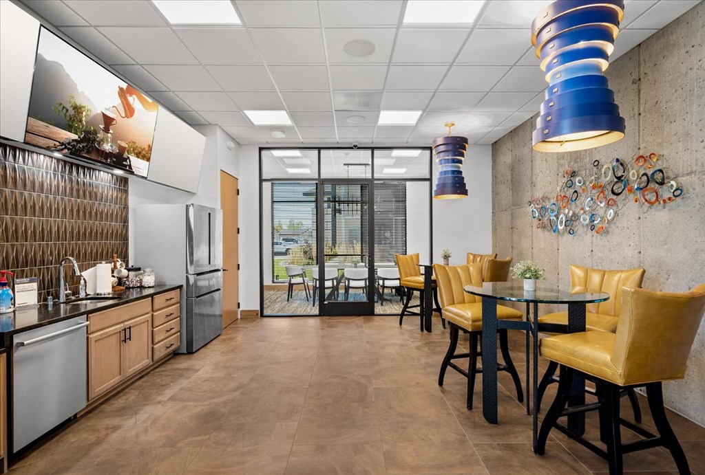 a dining room with a table and chairs and a kitchen with a sink