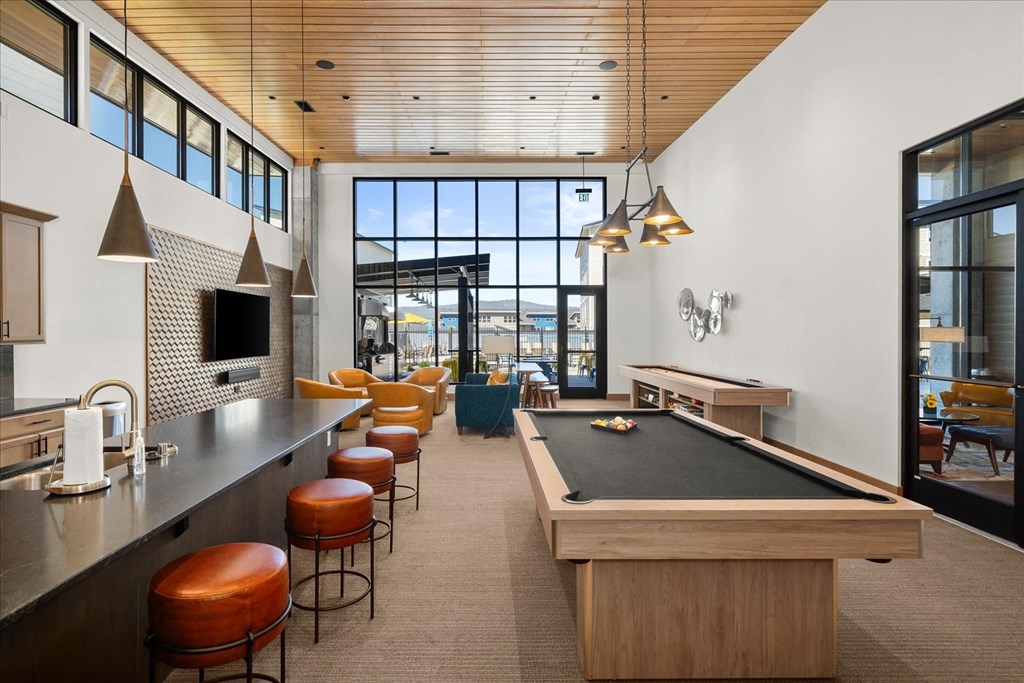 a game room with a pool table and a bar