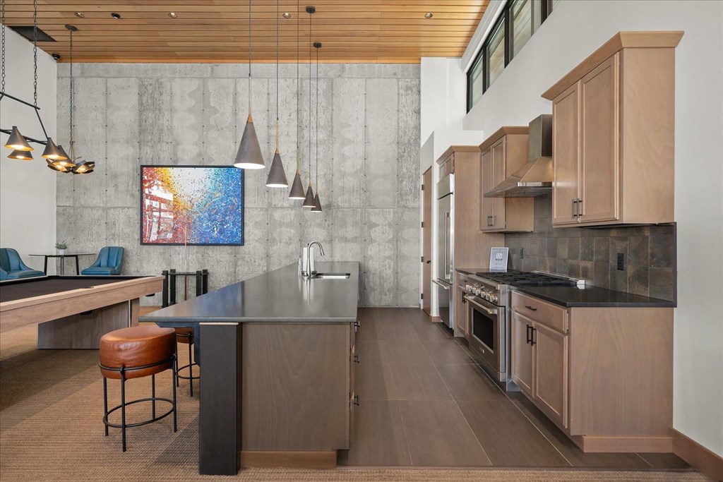 the kitchen has a large island and stainless steel appliances