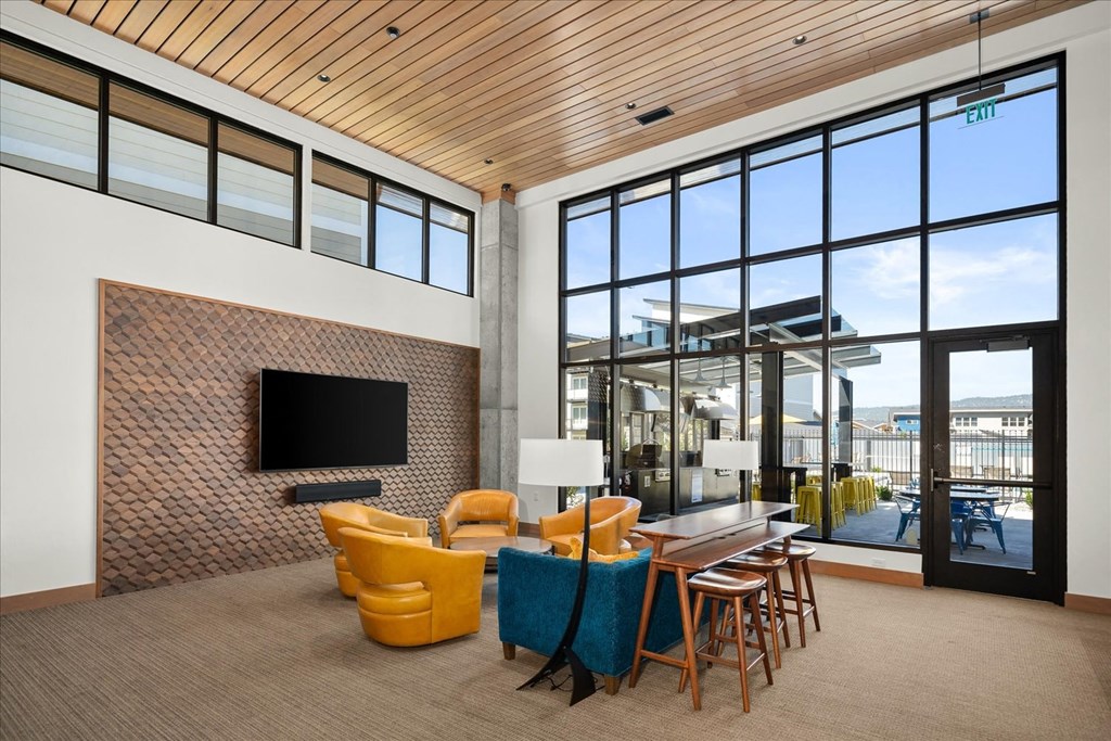 a living room with yellow chairs and a television