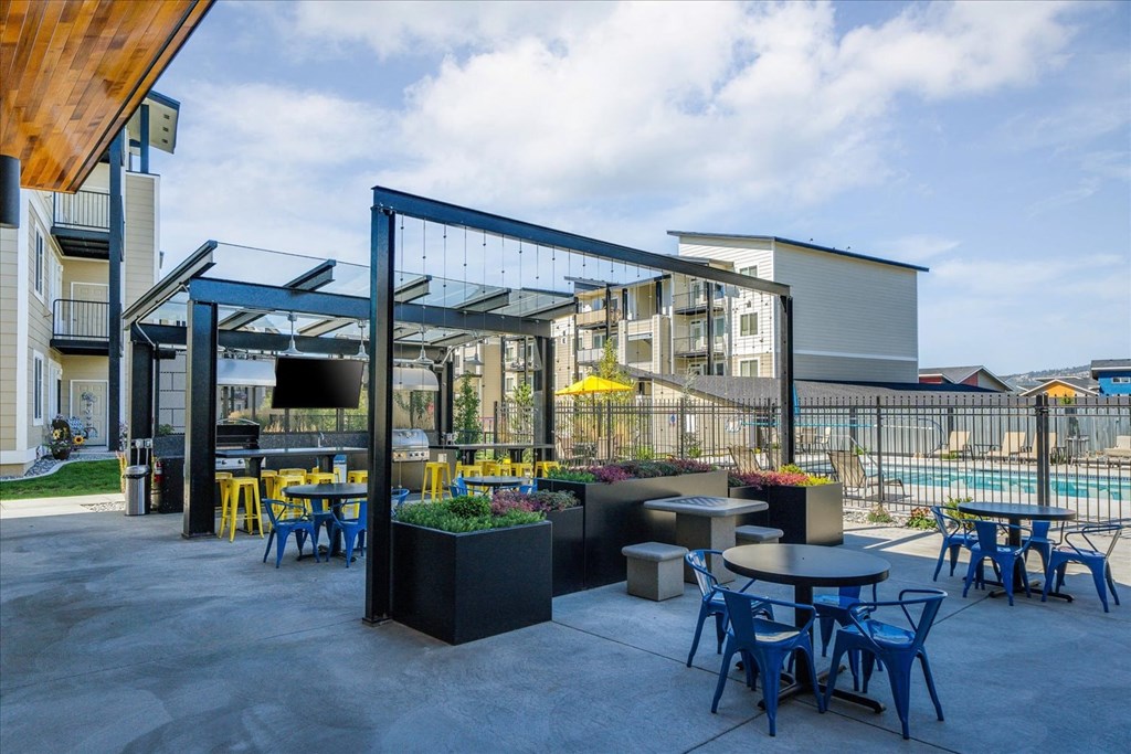 a patio with tables and chairs and a building in the background