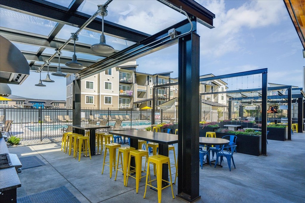 a patio area with tables and chairs and a pool
