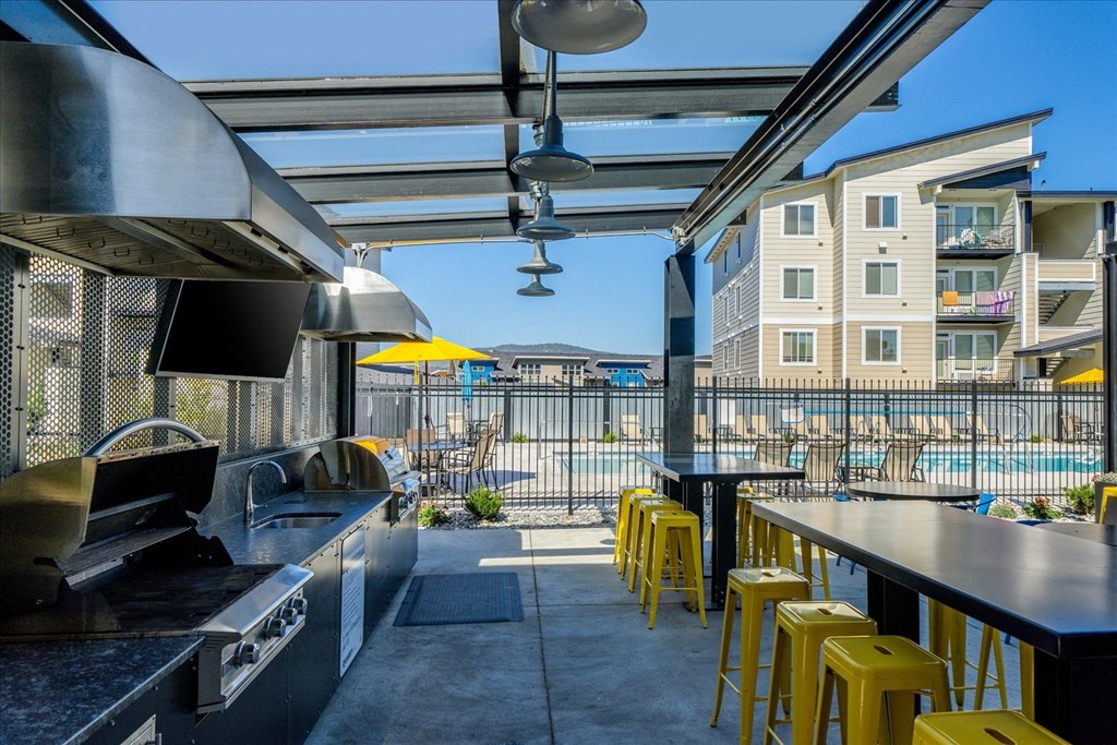 a kitchen with bar stools and a view of a pool and buildings