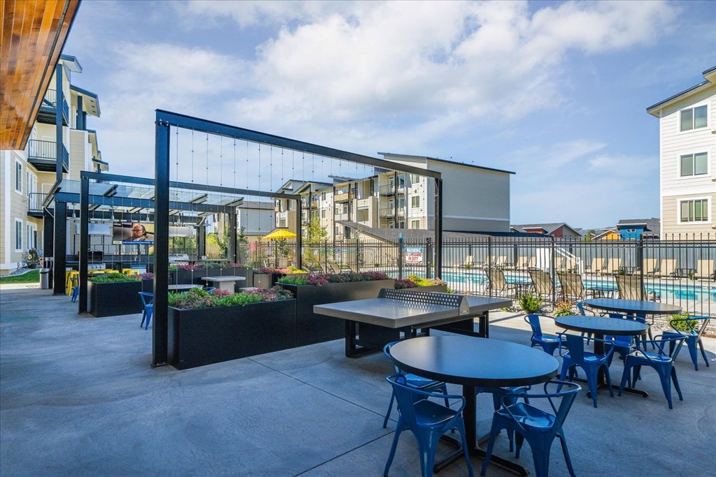 a patio with tables and chairs outside of an apartment building