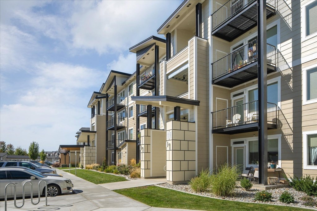 a row of apartment buildings with cars parked in front of them