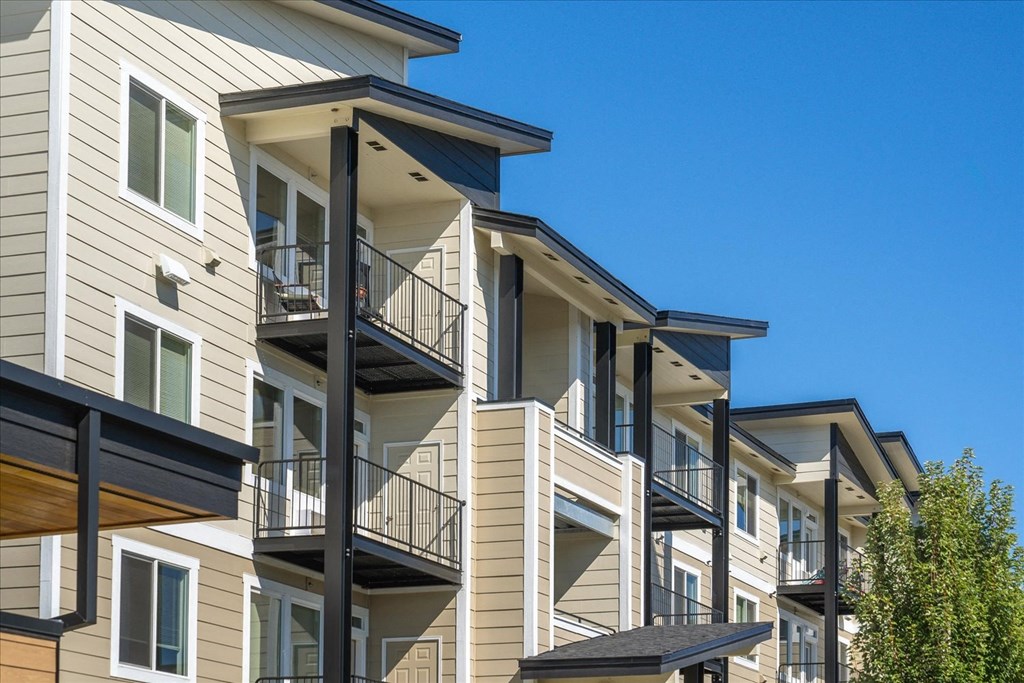 a row of apartments with balconies against a blue sky