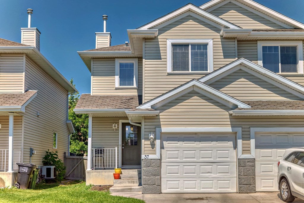 a tan house with a white garage door