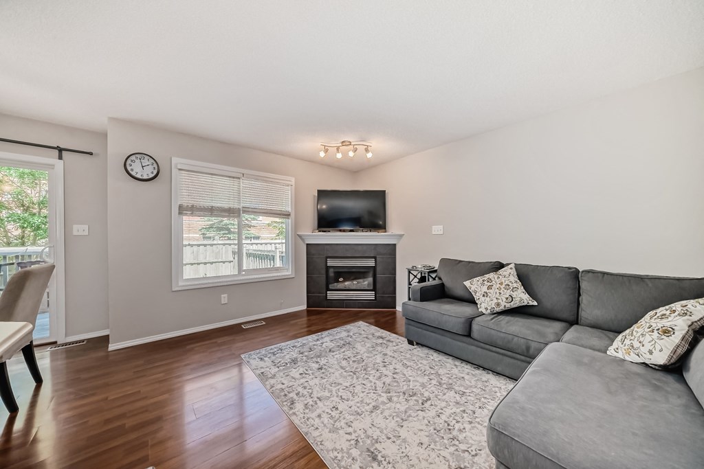 a living room with a couch and a tv in front of a fireplace