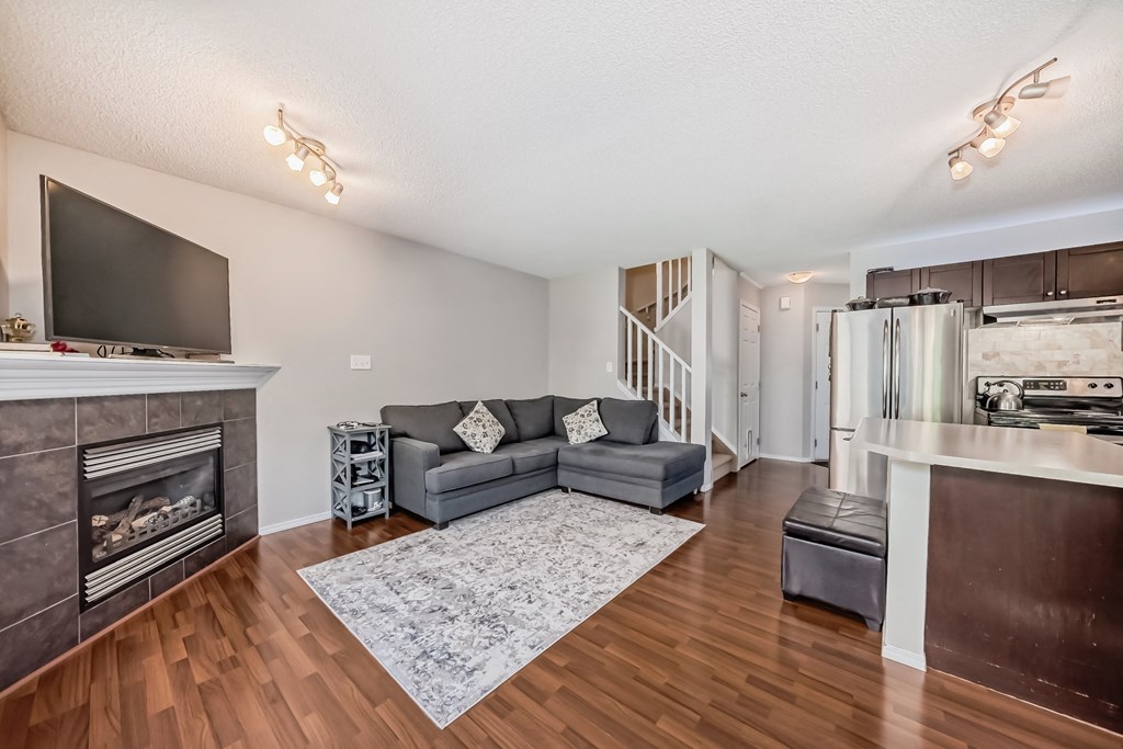 a living room with a couch and a tv and a kitchen