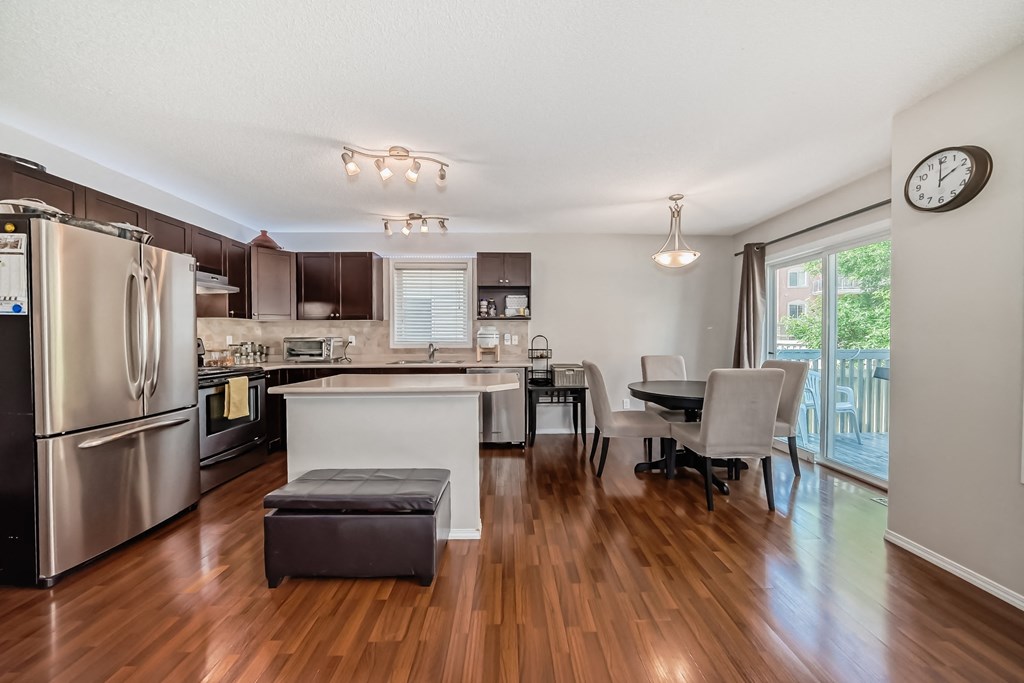 a kitchen and dining room with stainless steel appliances and wood flooring
