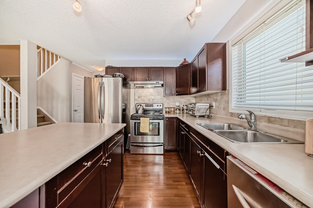 a kitchen with stainless steel appliances and wooden cabinets