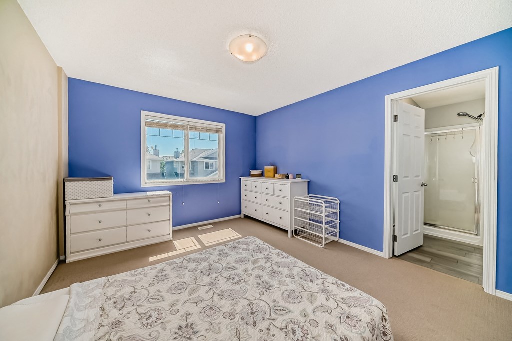 a bedroom with blue walls and white furniture and a bed