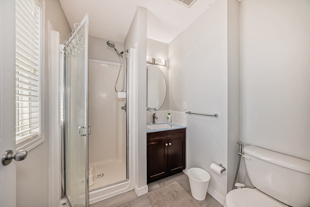 a bathroom with a shower and a sink and a toilet