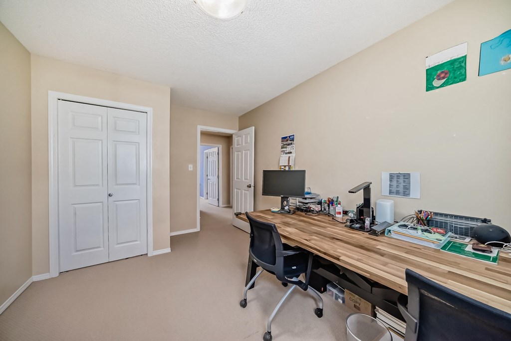 a home office with a large wooden desk and a computer