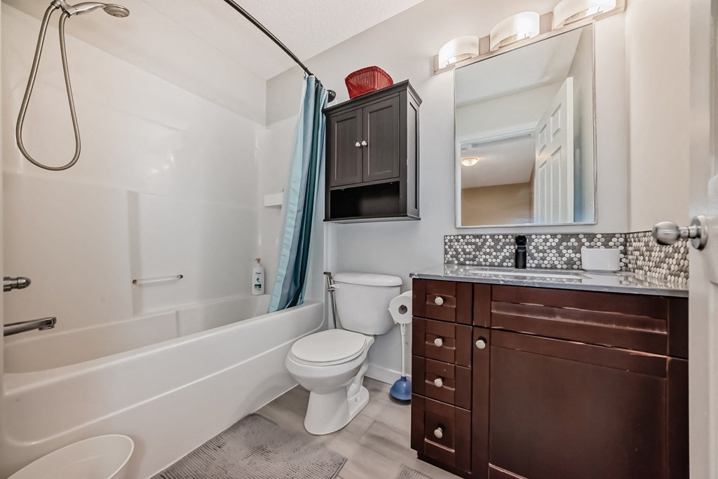 a bathroom with a toilet and a shower and a sink