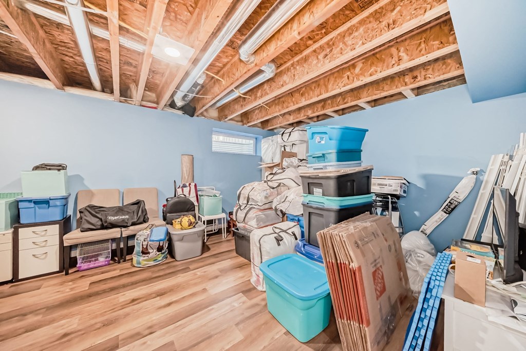 a room filled with boxes and furniture and a wood floor
