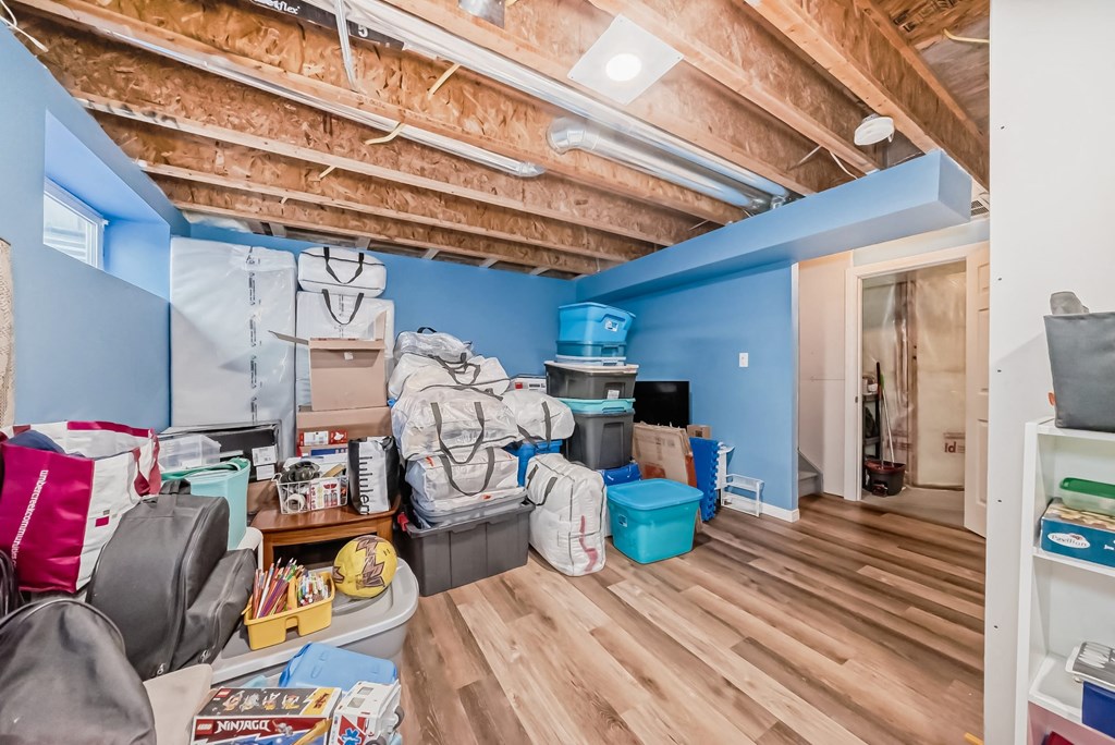 the attic of a house filled with boxes and bags on the floor