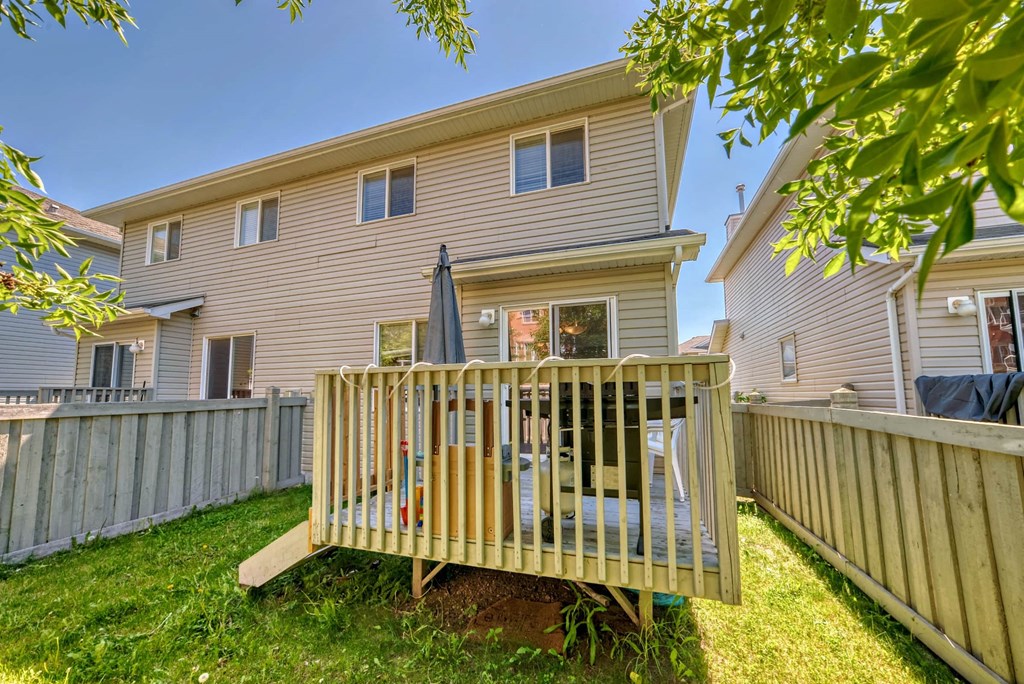the back of a house with a deck and a fence