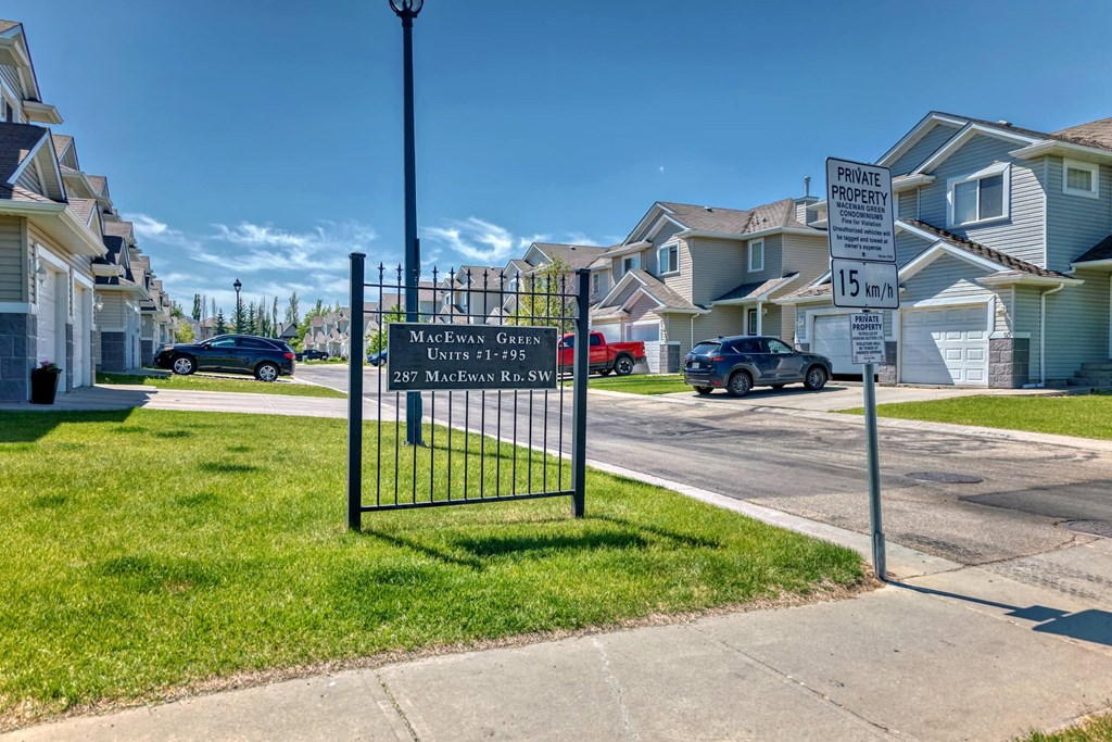 a gate with a sign on a sidewalk in front of houses