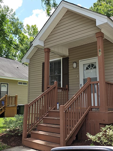 the front of a house with a wooden porch