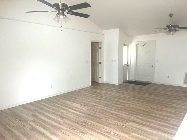 an empty living room with white walls and a ceiling fan
