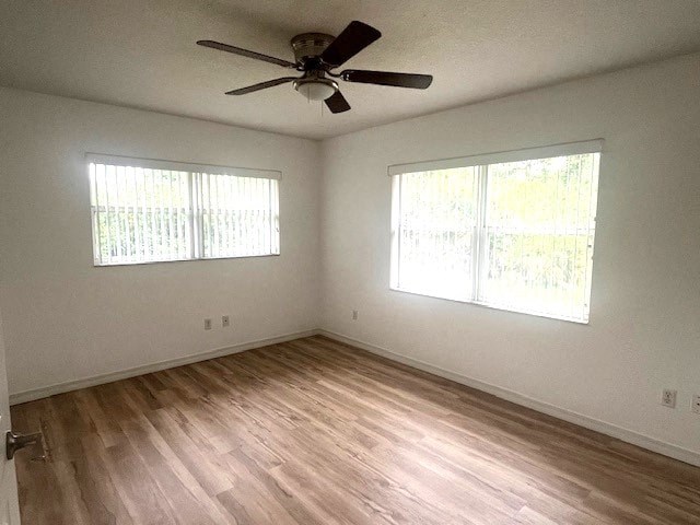 an empty living room with a ceiling fan