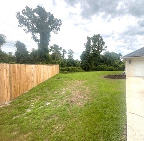 a backyard with a fence and a yard and a house