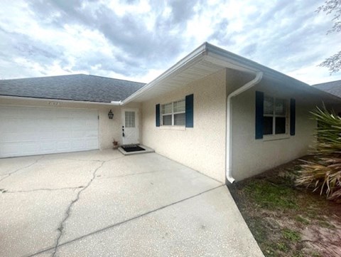 a white house with a driveway and a garage door