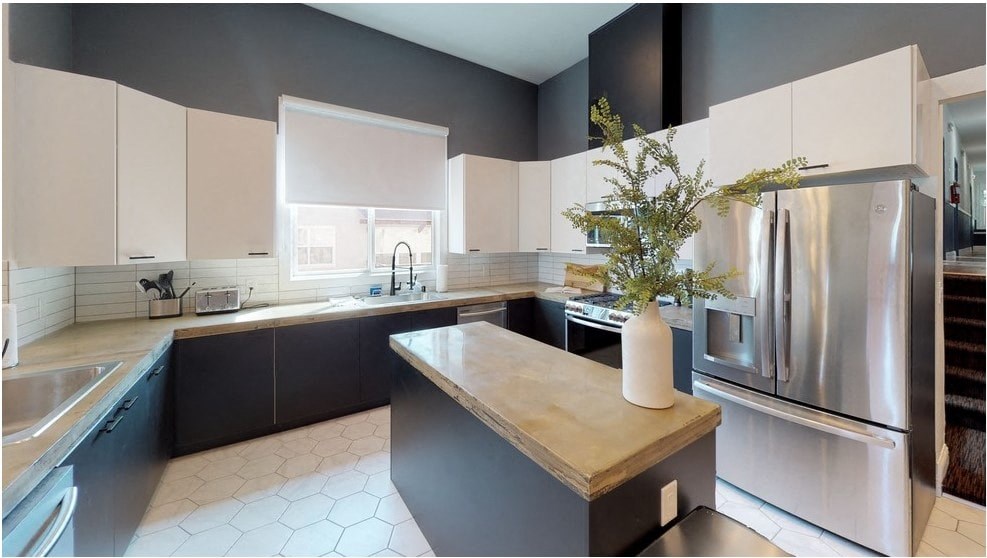 a large kitchen with stainless steel appliances and white cabinets
