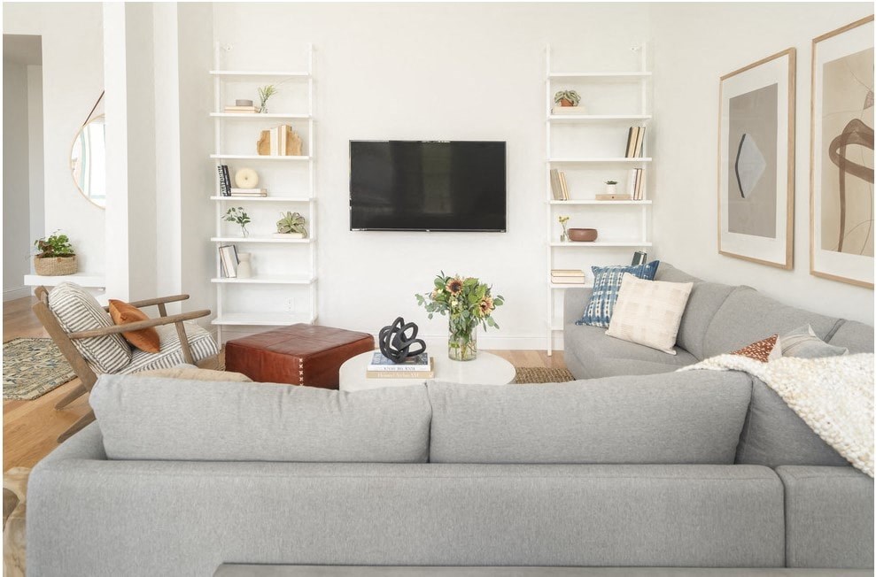 a living room with a gray couch and a television