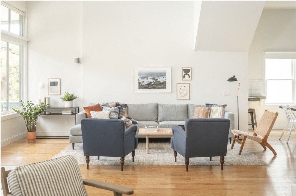 a living room with a gray couch and two blue chairs