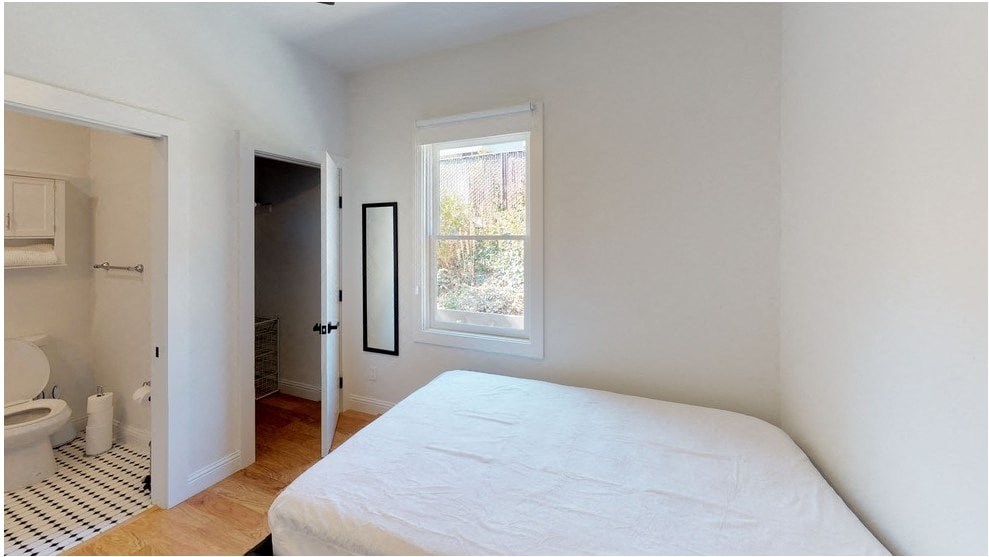 a bedroom with a bed and a bathroom with a toilet