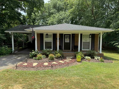 a front porch with a flower bed in front of a house