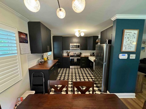 a kitchen with black cabinets and a checkered floor