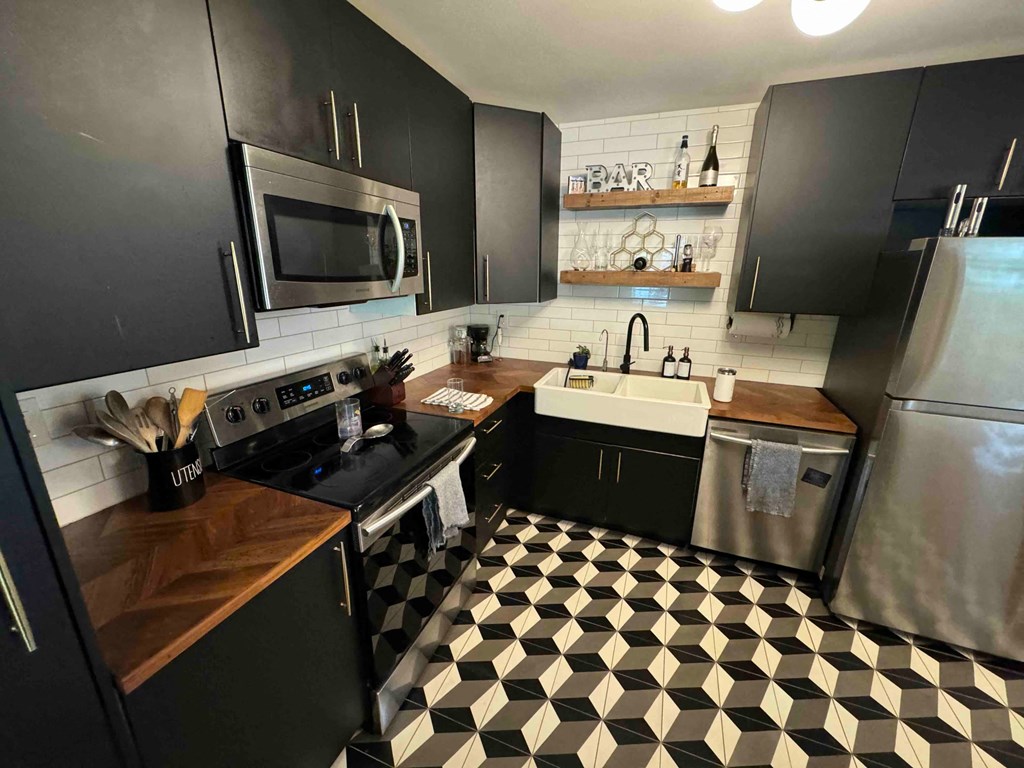 a kitchen with black cabinets and a checkered floor