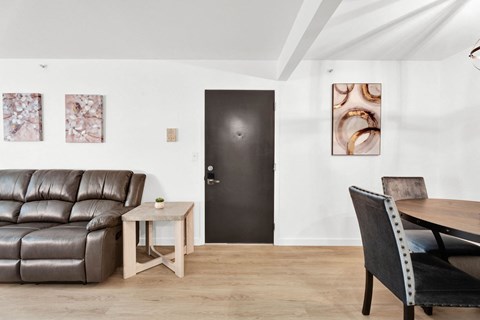a living room with a leather couch and a table and a black door