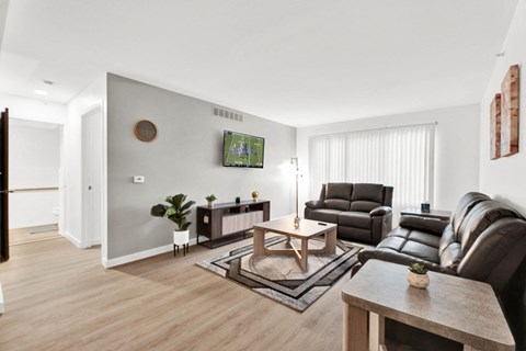 a living room with couches and a coffee table and a tv