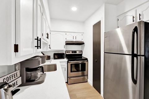 a kitchen with white cabinets and stainless steel appliances