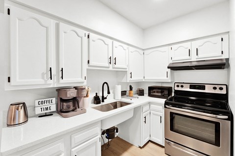 a kitchen with white cabinets and stainless steel appliances