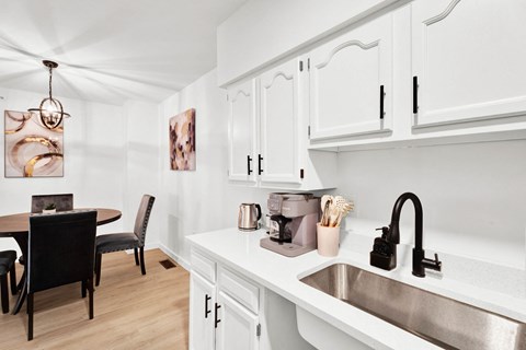 a kitchen with a sink and a dining room with a table