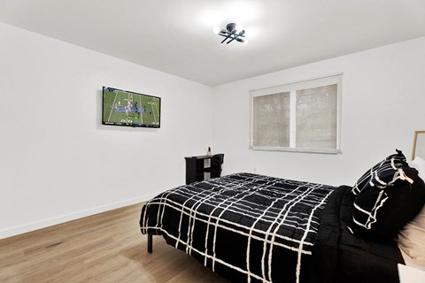 a bedroom with a bed and a tv on the wall