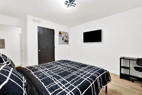 a bedroom with a bed and a black and white comforter