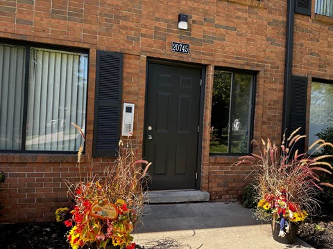 the front of a brick building with a black door