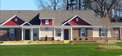 a home with red and white siding and a gray roof