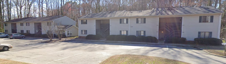 a white house with a garage and a parking lot