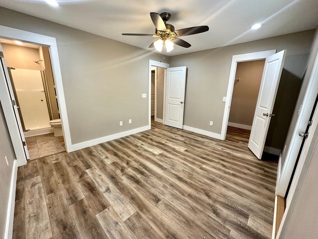 a living room with wood floors and a ceiling fan