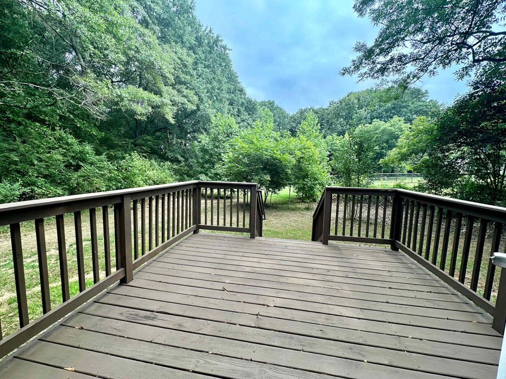 a wooden deck overlooking a body of water and trees